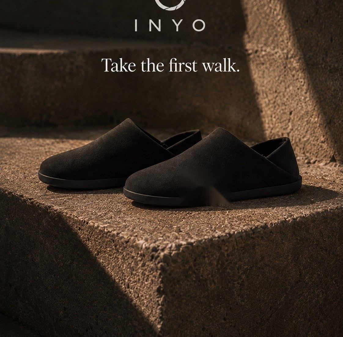 A pair of black Inyo Mules resting on sunlit stone steps.