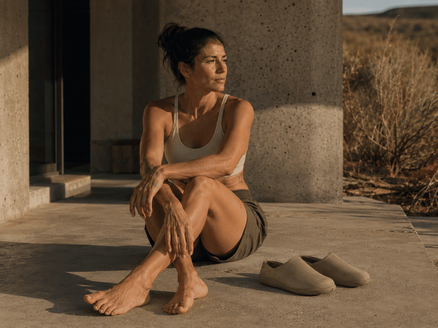 A person seated in a desert landscape after movement.